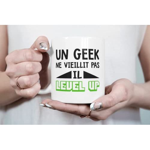 Tasse geek en céramique avec message humoristique Un geek ne vieillit pas, il level up, parfaite pour amateurs de jeux vidéo, résistant micro-ondes et lave-vaisselle.