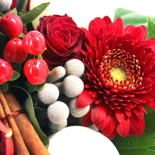 Bouquet de fleurs de Noël rouge et blanc avec germinis, roses, amaryllis et décorations festives.