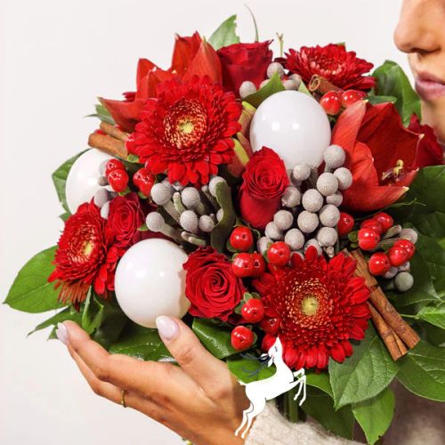 Bouquet de fleurs de Noël rouge et blanc avec germinis, roses, amaryllis et décorations festives.